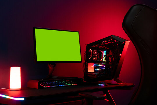 Powerful Gamer Rig personal computer with green screen monitor mockup stands on table at home