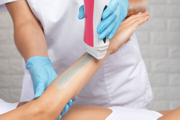 Obraz premium A beautician makes a sugar paste depilation of a woman's arms in a beauty salon.