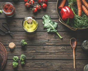 Food background with wooden spoon, healthy ingredients and kitchen utensils on rustic wooden table. Various vegetables, olive oil and spices.  carrots, tomatoes, broccoli, bell pepper. Top view. - obrazy, fototapety, plakaty