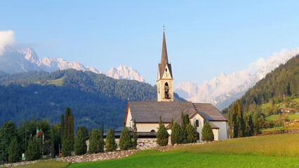Fototapeta premium Alpine mountain landscape with a catholic church in Italy. Panorama.