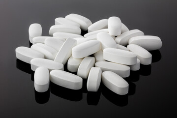 Many transparent tablets of vitamins isolated on a black background