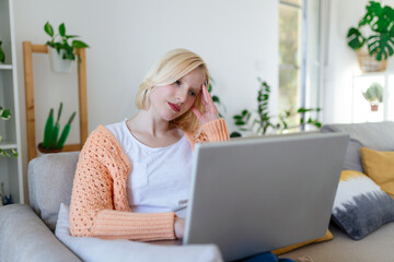 Young woman sit at home office reading email or contract feel confused with bad news, frustrated woman stunned by received paperwork correspondence