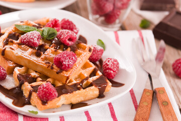 Waffles with raspberries and chocolate cream.