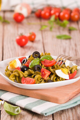 Fusilli pasta with cherry tomatoes, eggs and black olives.