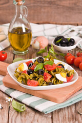 Fusilli pasta with cherry tomatoes, eggs and black olives.
