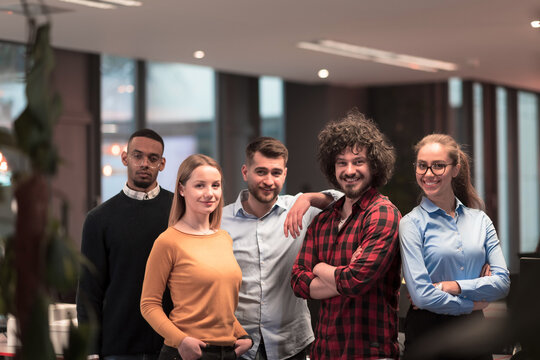 Portrait of successful creative business team looking at camera and smiling. Diverse business people standing together at startup. Selective focus 