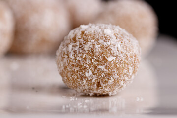 Beautiful sweets with coconut on a white plate on a black background