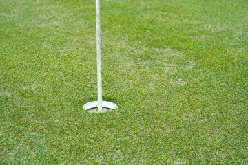 Obraz premium Top view of a golf course putting green with flag at hole.