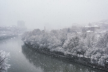 Aerial view at Mtkvari river or Kura river and trees covered with snow in Tbilisi, Georgia
