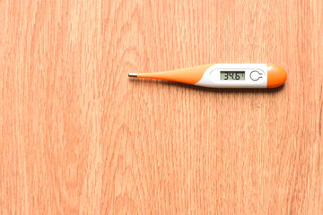 Digital thermometer on wooden background	
