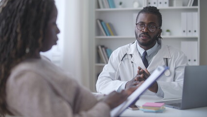 African American woman reading doctor prescription after healthcare check-up