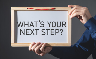 Man showing What's Your Next Step? on small whiteboard.