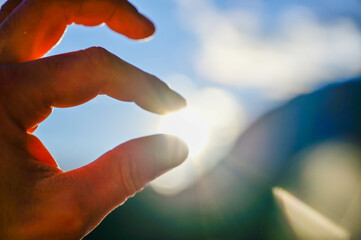 Sonne zwischen Finger