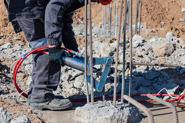 Hydraulic machine for bending rebar close-up. The worker bends the rebar release with a special tool. Construction of reinforced concrete foundations.