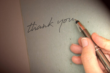 Hand writing thank you on piece of old grunge paper