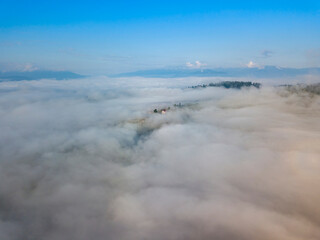 High flight above the clouds in the mountains. Aerial drone view.