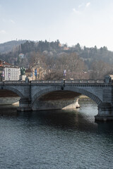 Vittorio Emanuele 1 bridge in Turin. Old architecture, in the background a mountain and a clear sky.