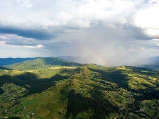 Fototapeta premium Rainbow in the mountains of the Ukrainian Carpathians. Aerial drone view.