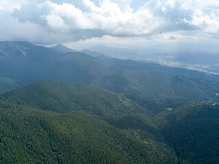 Fototapeta premium Green mountains of Ukrainian Carpathians in summer. Sunny day, rare clouds. Aerial drone view.