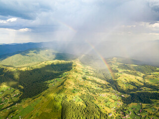 Rainbow in the mountains of the Ukrainian Carpathians. Aerial drone view.