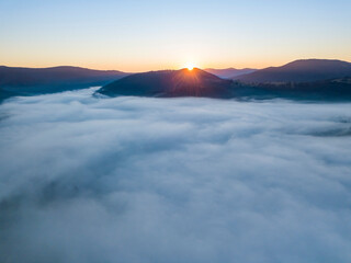 Sunrise over the fog in the Ukrainian Carpathians. Aerial drone view.
