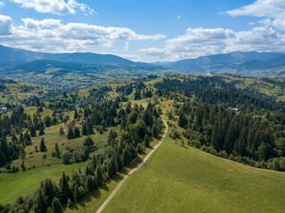 Green mountains of Ukrainian Carpathians in summer. Coniferous trees on the slopes. Aerial drone view.