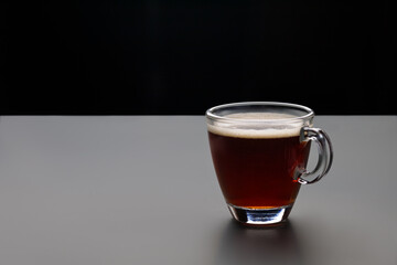 Cup of espresso coffee in glass, brew from arabica, on dark background. Arabica