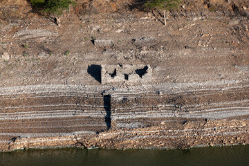 House or old construction made entirely of slate blending with the environment on the shore of strata by sediments