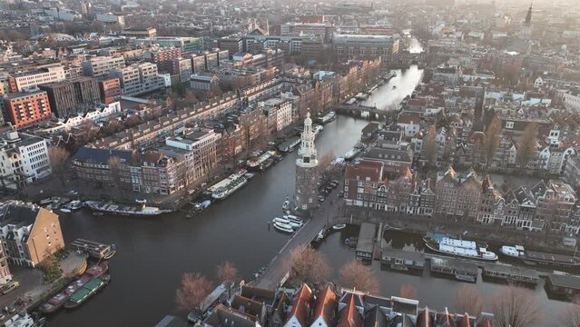 Montelbaanstoren Amsterdam urban canals Aerial city view at golden hour sunset. Historic city center. Facades touristic landmarks. Old tower church.