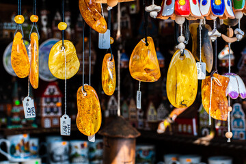 Necklaces and other amber souvenirs. Amber of different colors and sizes. Exposition of stones of amber for tourists, souvenir concept - obrazy, fototapety, plakaty