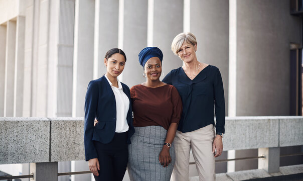 Surround yourself with strong women. Portrait of a group of businesswomen standing together against a city background.