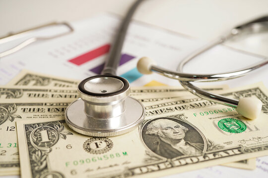 Stethoscope and US dollar banknotes on chart or graph paper, Financial, account, statistics and business data  medical health concept.