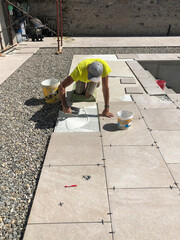 tiler placing glue for tile to built sidewalk