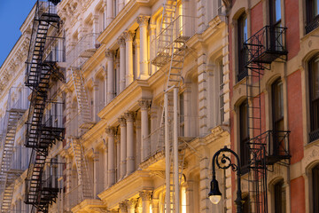Fototapeta premium Facades of Soho loft buildings with fire escapes at dusk. Lower Manhattan, New York City