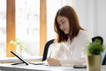 Atmosphere in the office of a start-up company, a female employee sits in the office, she is sitting in the sales department where she is making monthly sales summary to make a report to the manager.