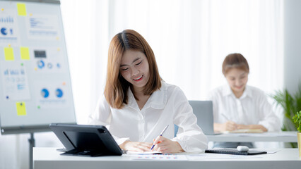 Atmosphere in the office of a start-up company, a female employee sits in the office, she is sitting in the sales department where she is making monthly sales summary to make a report to the manager.