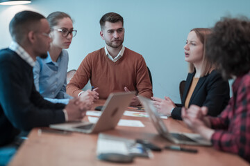 Successful team. Group of young multi-ethnic business people working and communicating together in creative office. Selective focus 