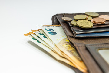 Open brown leather wallet with money and credit cards