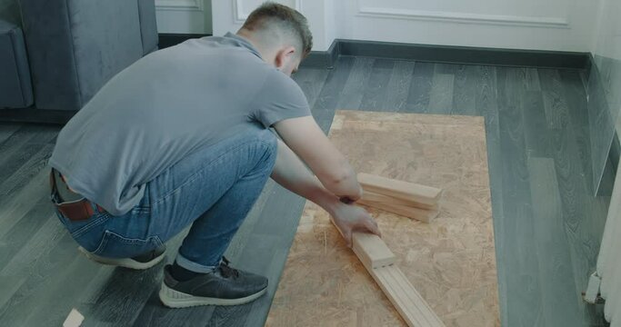 Man is building furniture himself making renovation at home. Master repairman is working assembling furniture