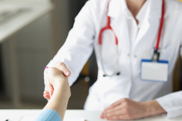 Doctor woman greet patient and shake hand, medical worker in uniform