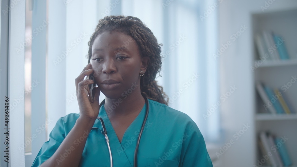 Wall mural sad african-american female doctor informing patient about bad diagnosis on phone