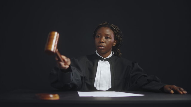 Confident African American female judge tapping gavel, announcing court order