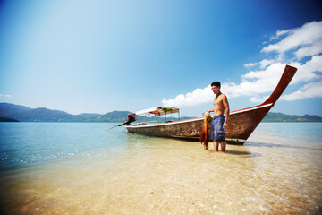 Ready to get to work. Traditional Thai long tail boat on the beach - Thailand.