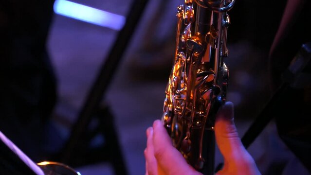Saxophone player. Hand of musician playing jazz saxophone during live performance on stage
