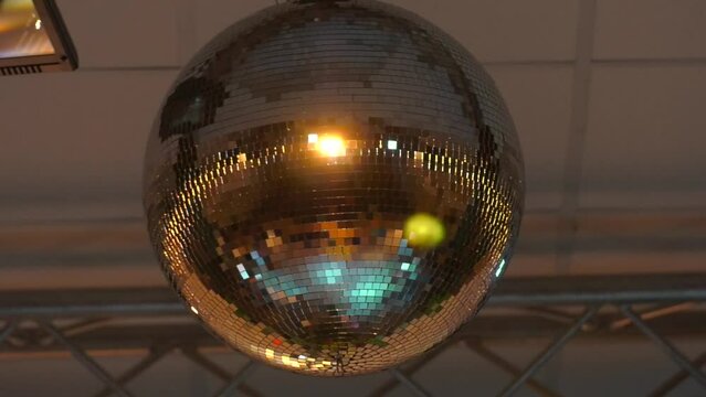 Mirrored Disco Ball and bright beams at the night party. Party attribute reflects Lazer lights. Abstract background with defocused rays. 
