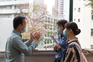 university or college male teacher with face mask explains to asian female students during field test beyond classroom in university in Hong Kong during covid-19 - obrazy, fototapety, plakaty
