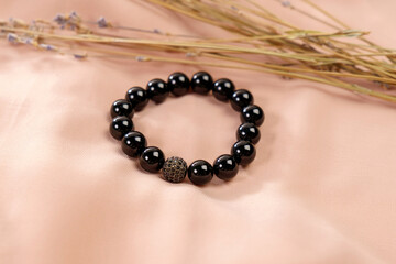 Decoration is a bracelet made of black agate. Natural stone jewelry.