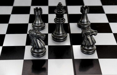 The king in a battle chess game stands on a chessboard with a black isolated background. Business Leadership Ideas.