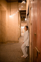 Woman tourist walking in Al Seef Meraas Dubai - old historical district with traditional Arabic architecture