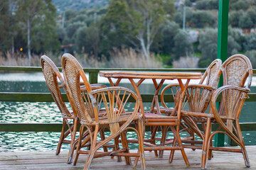 Empty table with river and trees view. Wooden garden furniture. Peaceful, nice and quiet veranda.